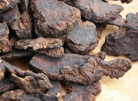 dried herb pieces and blocks of Rehmannia Root are in a pile