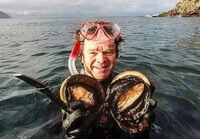 I pescatori tengono in mano molluschi di Haliotis ruber Leach.