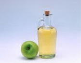 light yellow apple cider vinegar and a green apple
