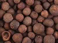 brownish dried herb grains of Jamaica pepper are piled together