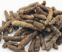 brownish dried fruit spikes of Piper longum are piled together