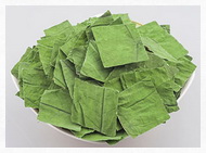 dried green square pieces of lotus leaf herb are piled in a plate