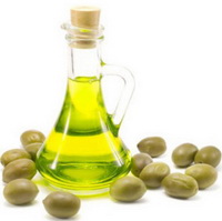 yellow olive oil in a glass bottle and many green olive fruits
