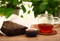 black tea brick and a glass cup of black tea drink